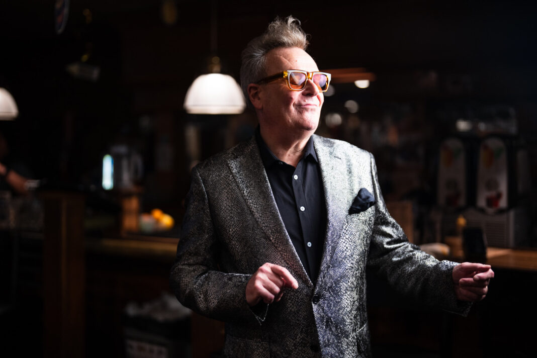 Interview: Greg Proops on Protest Punchlines, Political Chaos, and Why Satire Still Hits Hard